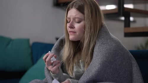Une femme malade et fatiguée se mouche en pulvérisant un spray nasal au Ralenti Portrait d'un Caucasien malade