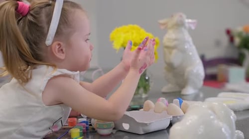 Child Decorating Easter Eggs with Family