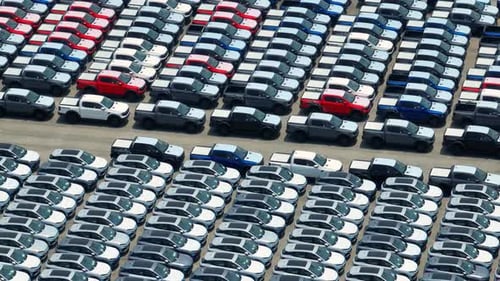Aerial view of a parking lot full of cars in neat rows. 4K.
