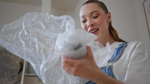 Apartment Tenant Unpacking Boxes in New Home Closeup Cheerful Woman Unwrapping