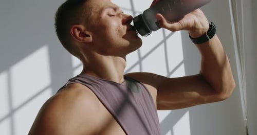 Man Drinking Water From Bottle After Workout