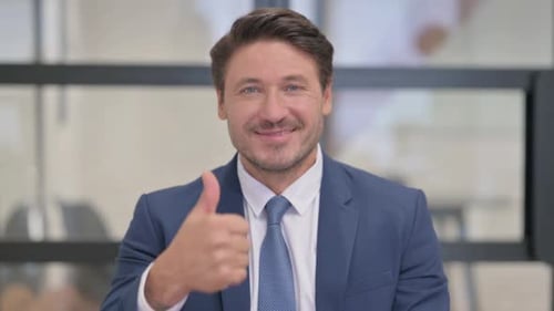 Man in Suit Gives Thumbs Up Indoors
