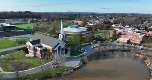 Elizabethtown Etown College. Aerial of lake pond and chapel. Establishing shot of university campus