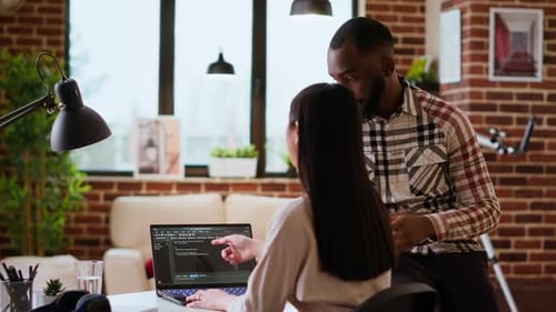 Interracial Creative Team Programing Code on a Laptop and Debugging