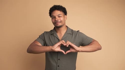 Man Makes Heart Shape with Hands