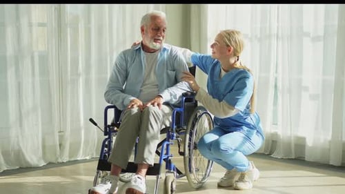 Medical Professional Helping Elderly Man in Wheelchair