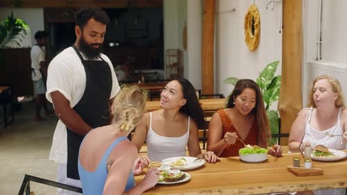 Waiter Interacts with Multicultural Female Customers Dining at Ecofriendly Cafe Multiethnic Women