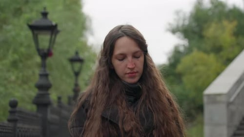 Woman Standing sadly with Umbrella in Urban Park