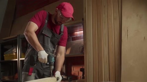 An Experienced Carpenter Demonstrates Various Drills and Techniques While Working in a Wellequipped