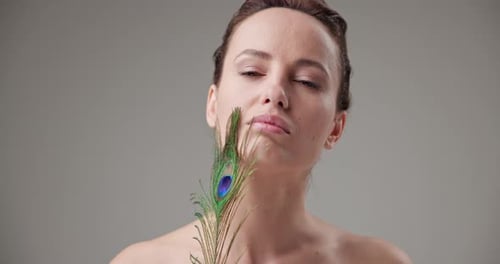 Woman Posing with a Peacock Feather in Studio