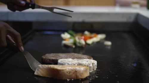 Chef Hands Cooking Grill Salmon, Cord Fish and Beef Steak on Satake Frying Table at Japanese Restaur