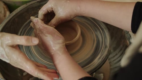 Hands Forming Clay Bowl on Pottery Wheel
