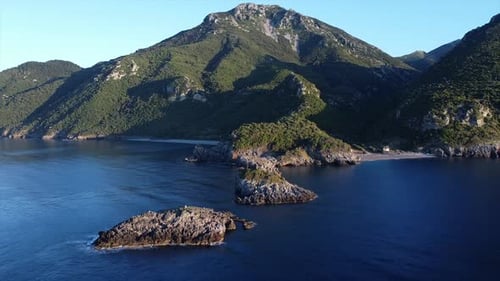 Aerial Footage of a small beach near the mountain and a forest