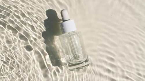 Serum Bottle on Rippling Water Background