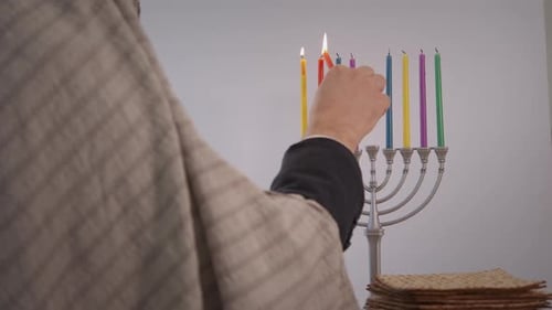 Person Lighting Hanukkah Candles on Silver Menorah