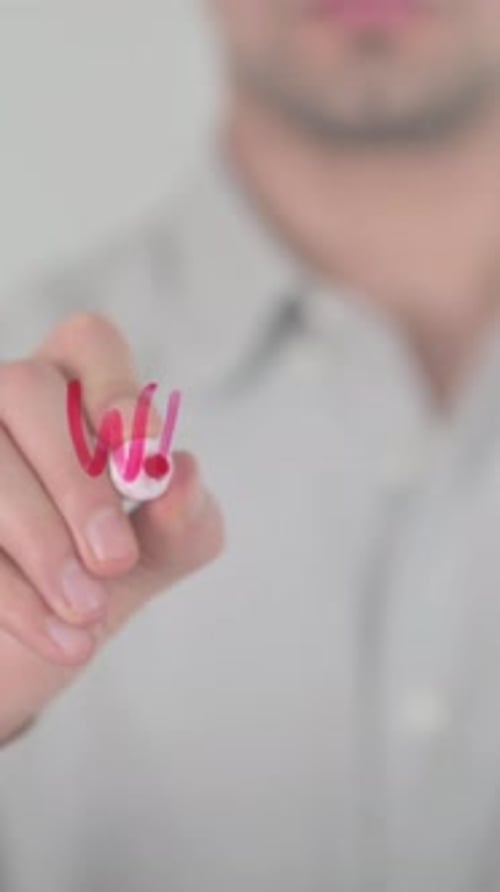 Man Writes the Word Design on Glass