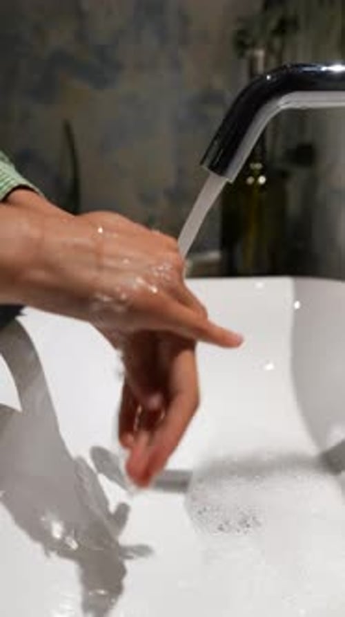 Hand Washing with Soap in White Sink