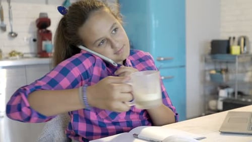 Teenage Girl Chatting on Phone in Kitchen