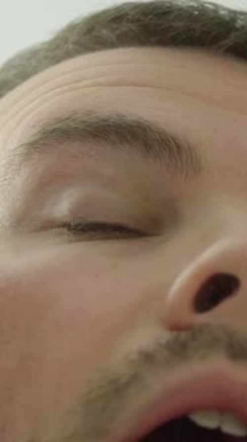 Close-up of man applying eye drops