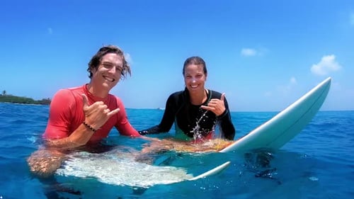 Couple Surfing Together in Turquoise Tropical Ocean