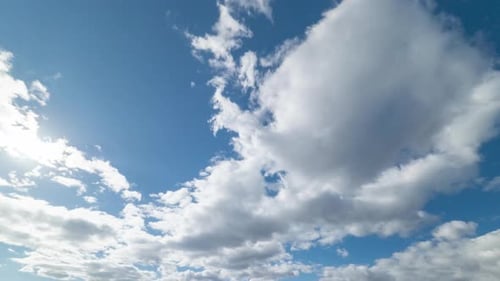 Fluffy White Clouds Moving Across Blue Sky