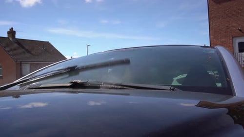 Windshield wiper test with water spray blue sky background