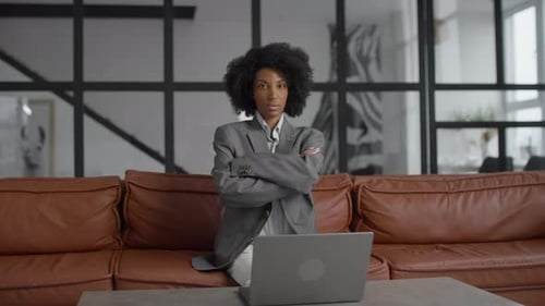 Confident Businesswoman Sitting with Arms Crossed in Office