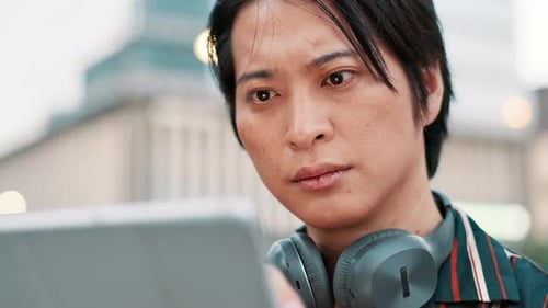 City, face and tablet with Japanese businessman outdoor for problem solving, research or thinking