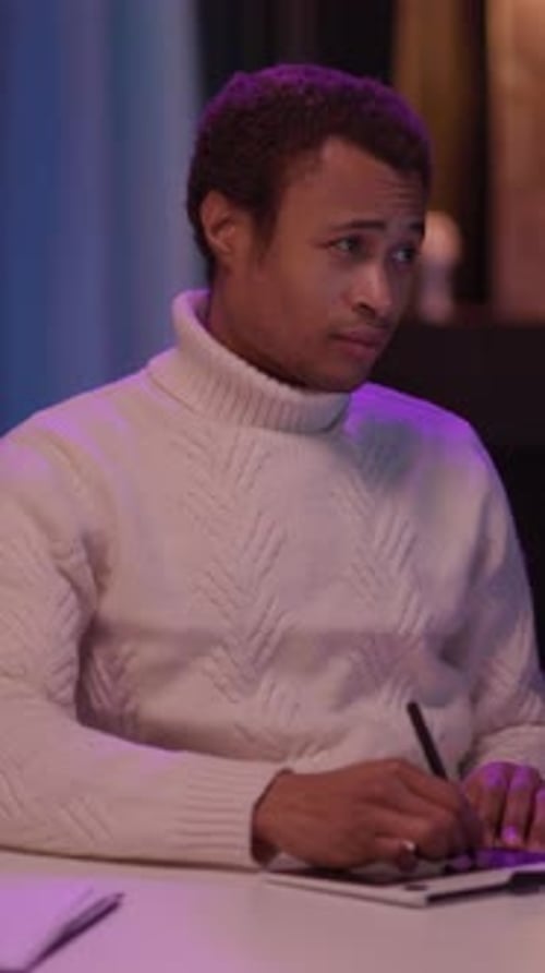 A Young Man in a Turtleneck Creates at a Cozy Table Setting