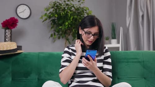 Woman Using Smartphone While Relaxing on Couch