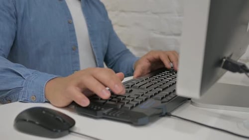 Close up of Man Typing on Keyboard of Computer