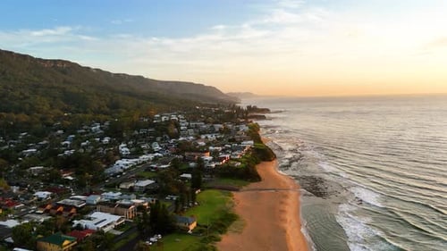 Long Sand Stretch at Thirroul Beach With Rising Hills and Sunrise Aerial Dolly