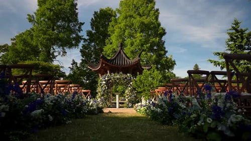 A view of a beautiful wedding reception set up in a lush garden, captured in the soft light of a lov