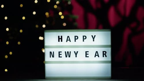 Tabuleta de feliz ano novo sob a árvore de Natal