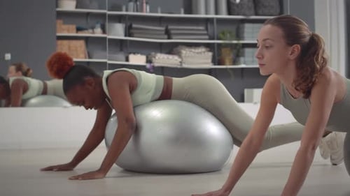 Women Work Out Together Using Exercise Balls