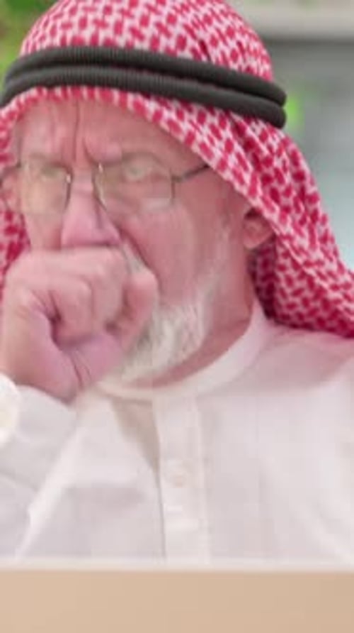 Senior Man with Keffiyeh Coughing into Hand Outdoor