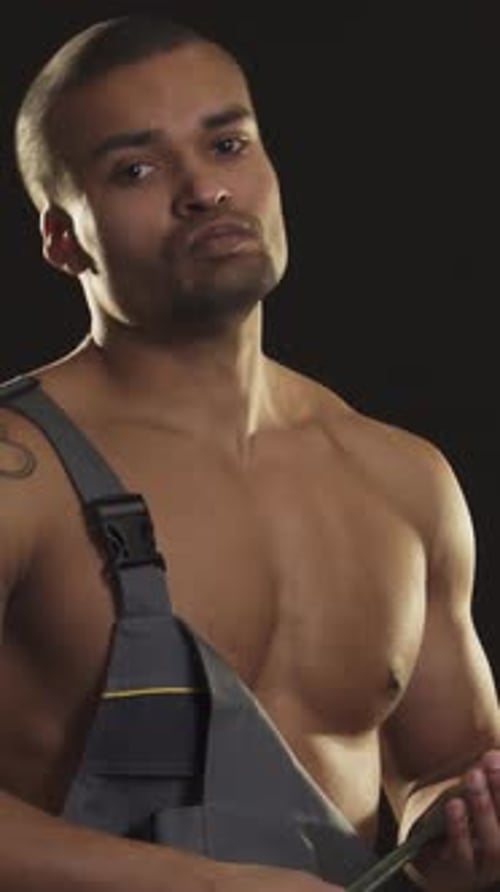 Fierce Muscular Mechanic Brandishing a Wrench with Intense Determination