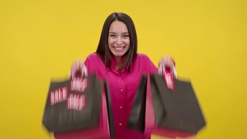 Excited Woman Holding Shopping Bags with Sale Tags