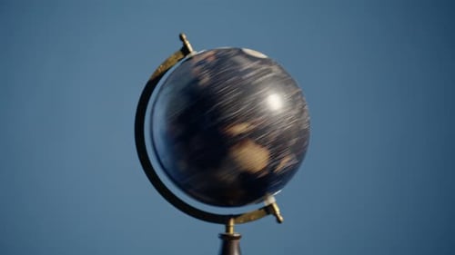 Handspinnender Vintage-Globus auf blauem Hintergrund, Nahaufnahme, Reisender, rotierende Erde