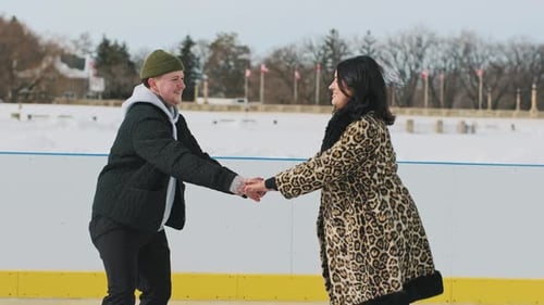 Man teaching woman how to ice skate on a frozen lake on a sunny winter day.
