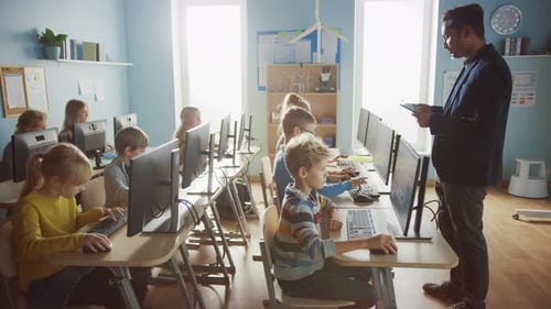 Elementary School Computer Science Classroom: Teacher Uses Tablet Computer, Explains Lesson to Dive