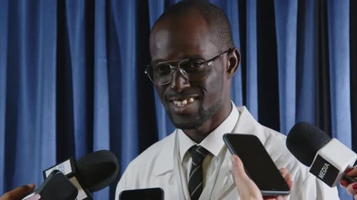 African American Medical Expert Giving Interview to Group of Journalists