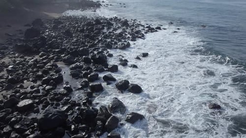 Aerial View of Waves Crashing on Rocky Shoreline