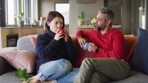 Couple Relaxing on Sofa at Home, Drinking Tea