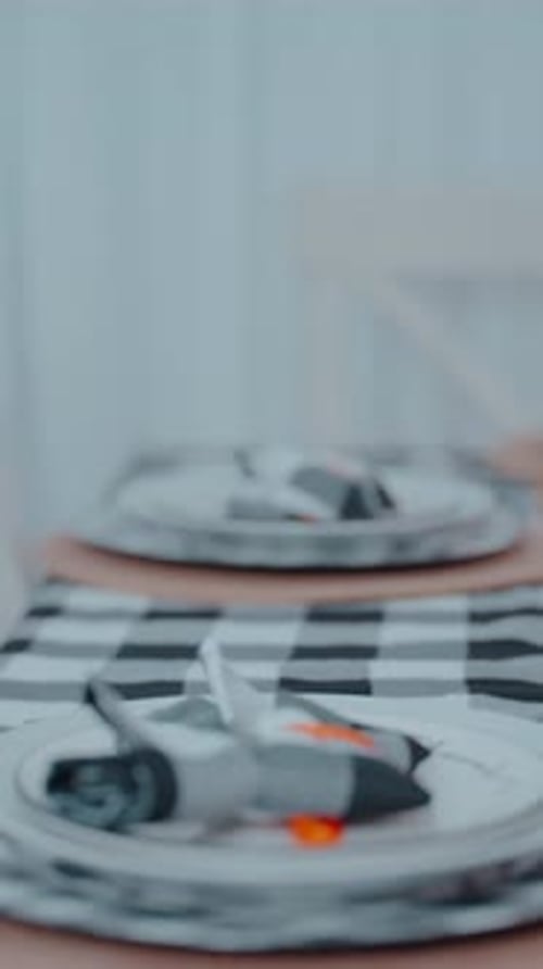 Minimalist Thanksgiving table setting with a white plate, checkered napkin tied with an orange ribbo