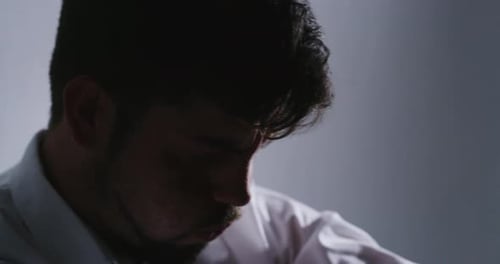 A businessman having a nervous breakdown on the floor and laughing inappropriately