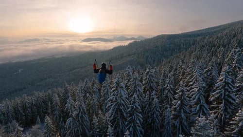 Action de parapente : vol à proximité au-dessus de la forêt hivernale, aventure en toute liberté et adrénaline