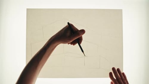 Young Man Artist is Drawing Buildings By Pencil on White Paper Top View The Architect Making