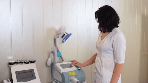Woman Operates Medical Device in Clinic