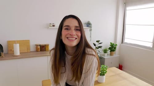 Smiling Woman Sitting in Bright Modern Kitchen